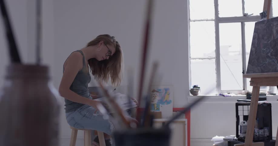A woman looking at a canvas in an art studio