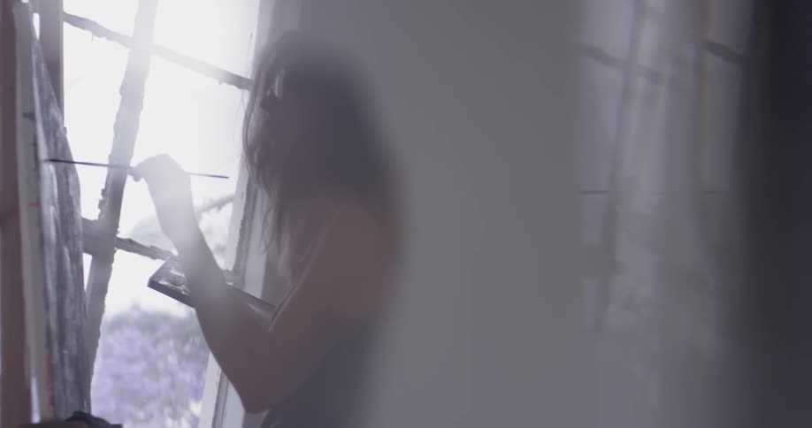A woman getting paint off a palette