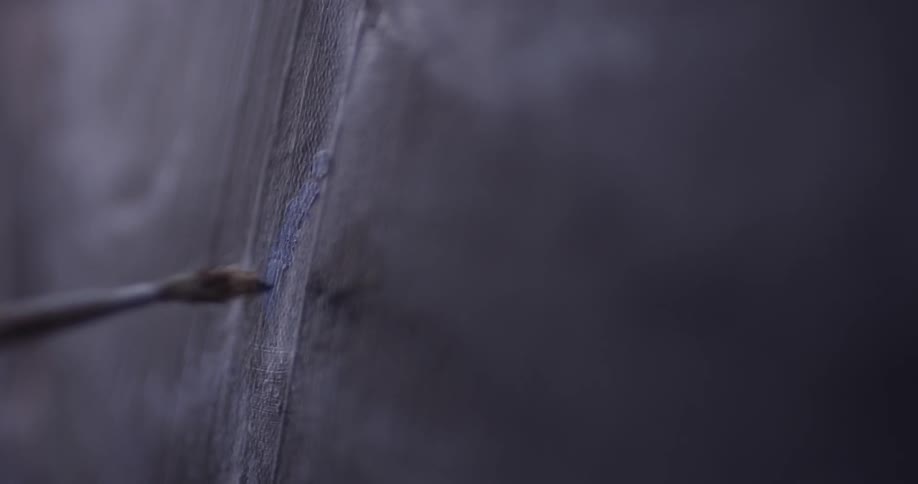 A paintbrush that is touching a canvas