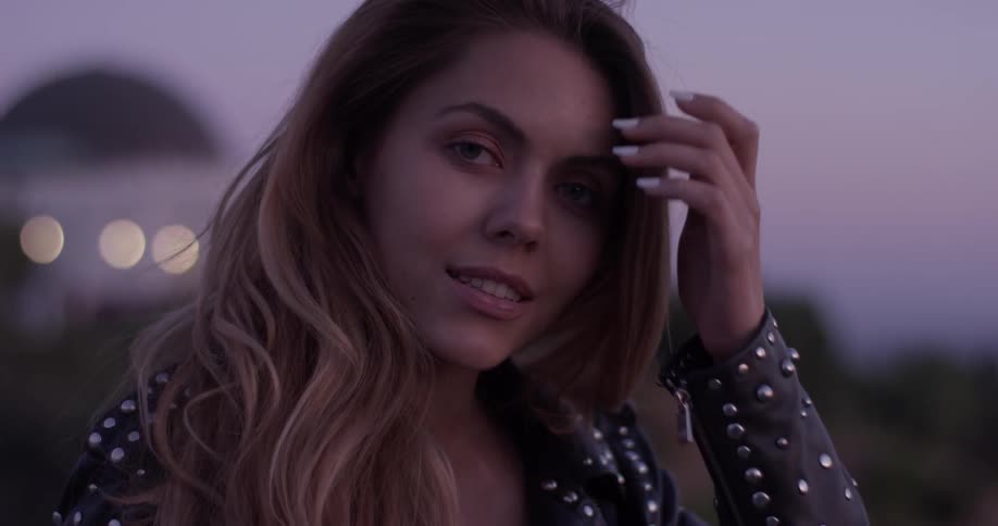 Woman looking into the camera at dusk
