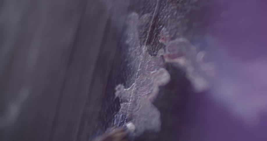 Closeup of a paintbrush brushing white paint onto a canvas