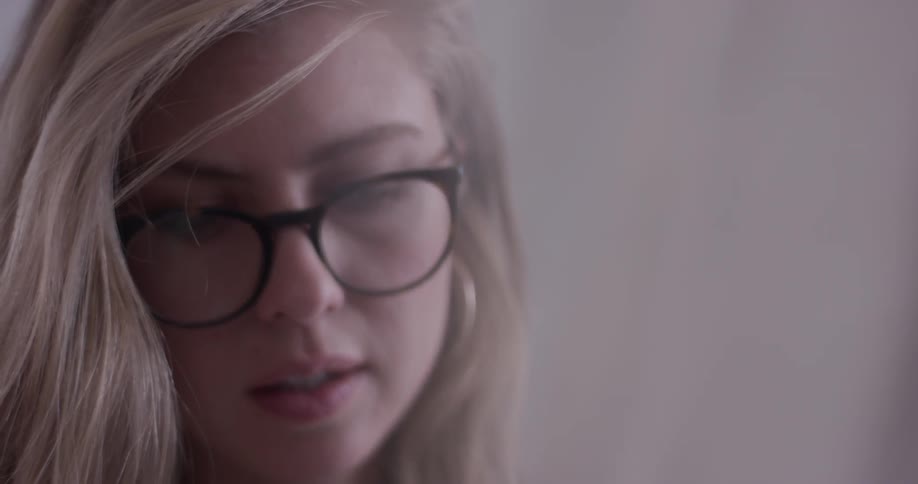 A woman wearing glasses is drawing