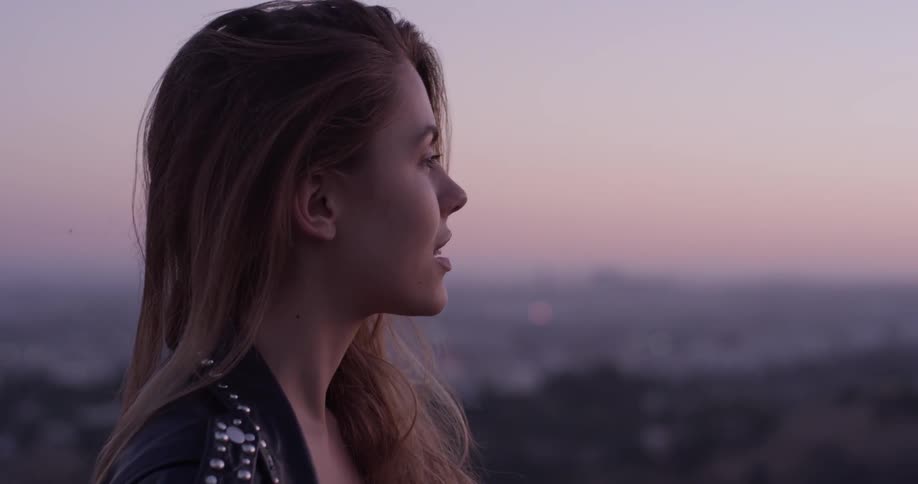 Woman smiles and looks out at the city below