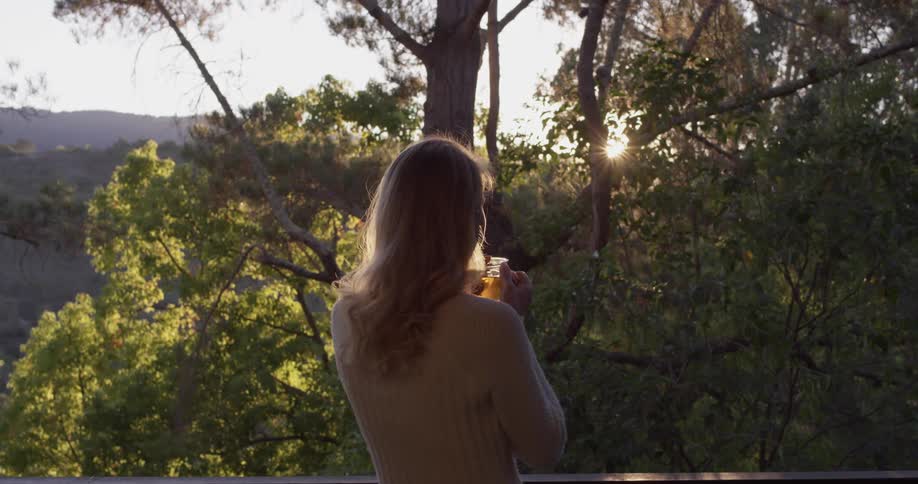 Woman holding a glass of tea outdoors