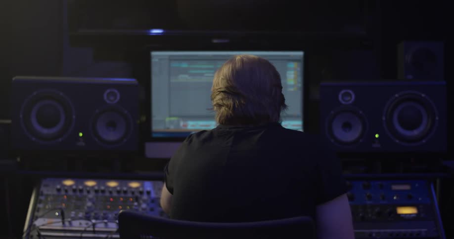 A person sitting in front of audio and video controls