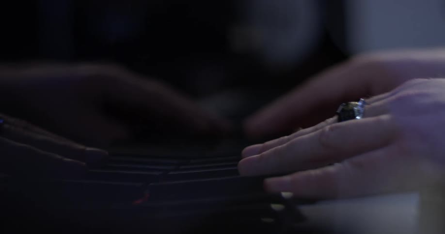 A person playing a piano while wearing a ring