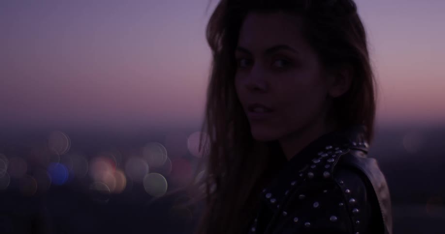 Woman looking over the city at sunset