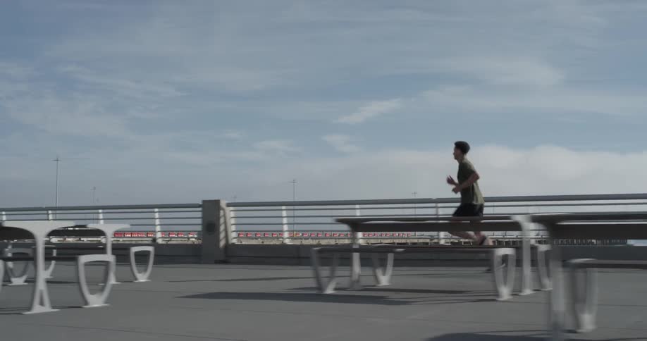 A person running down the sidewalk next to a river