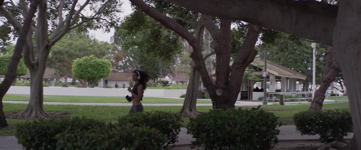 Woman jogs in a park on a cloudy day