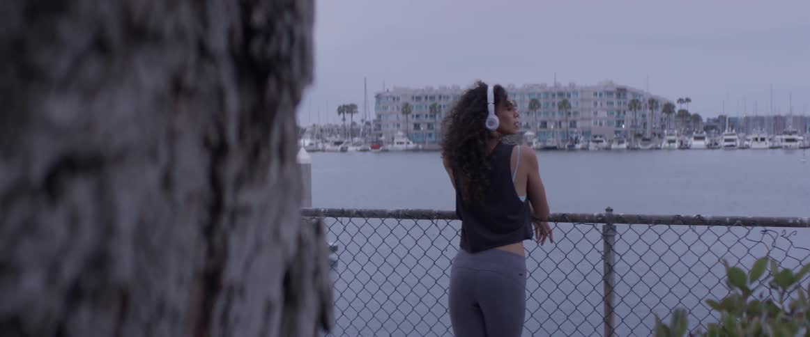 A woman is looking at the skyline by the beach