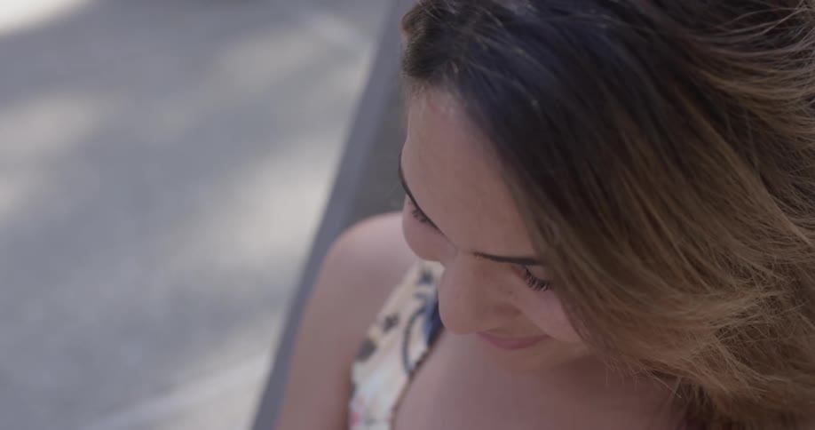 Closeup of a woman sitting in a chair looking down at something in her lap