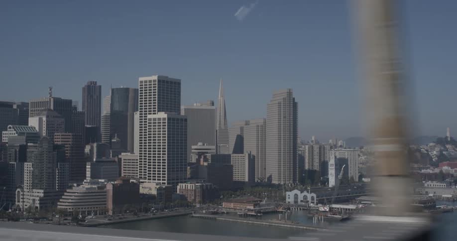 Driving over a bridge into a city with tall buildings