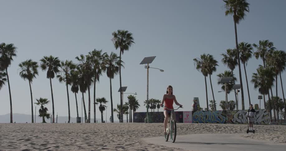 Woman riding a bicycle down a sidewalk