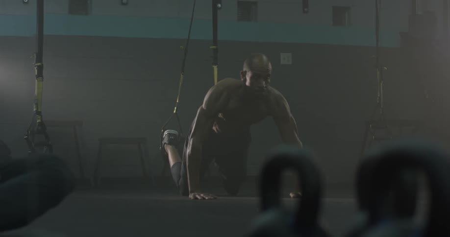 A man putting his foot into a sling at a gym