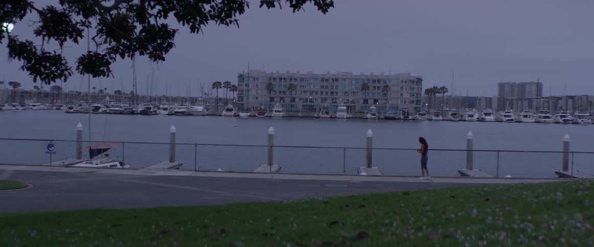 A person standing beside a fenced water area