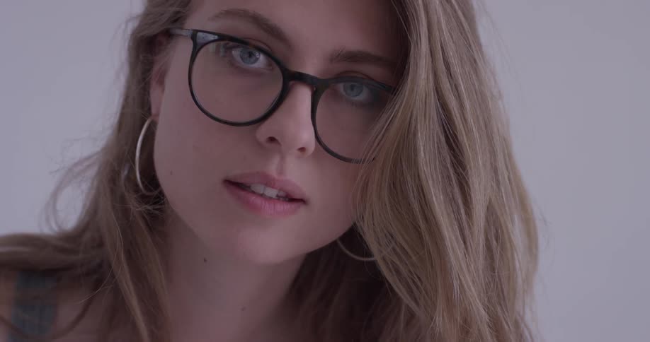 A woman in glasses turning and looking at someone