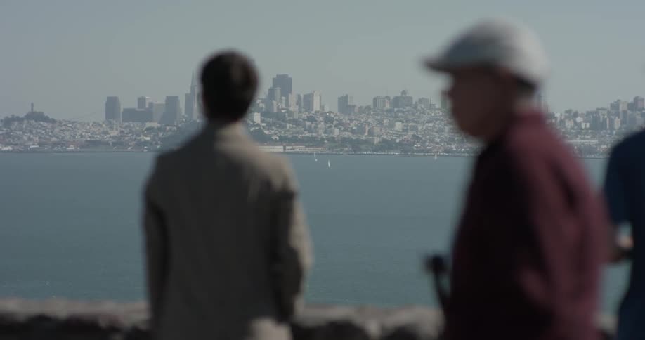 A man looking across a bay at a city