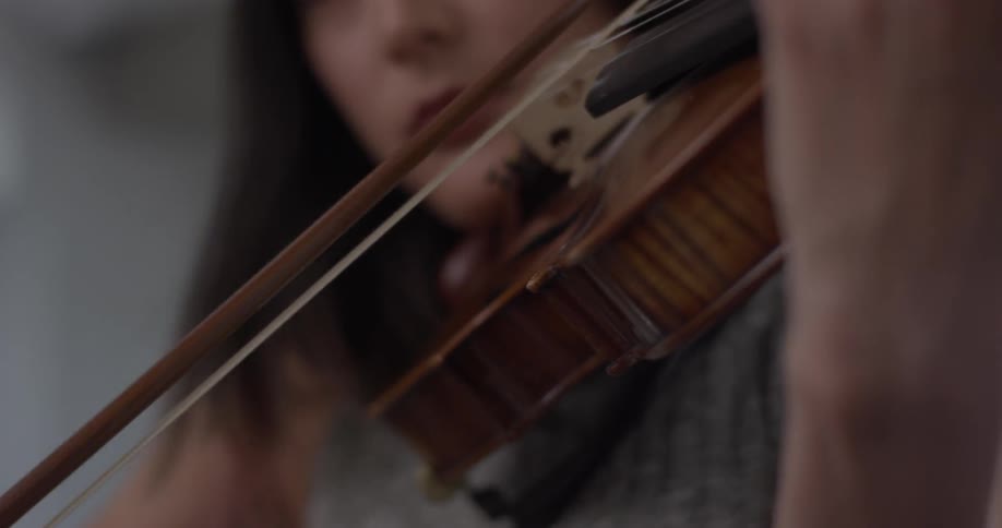 A closed up of a woman playing the violin with her eyes closed