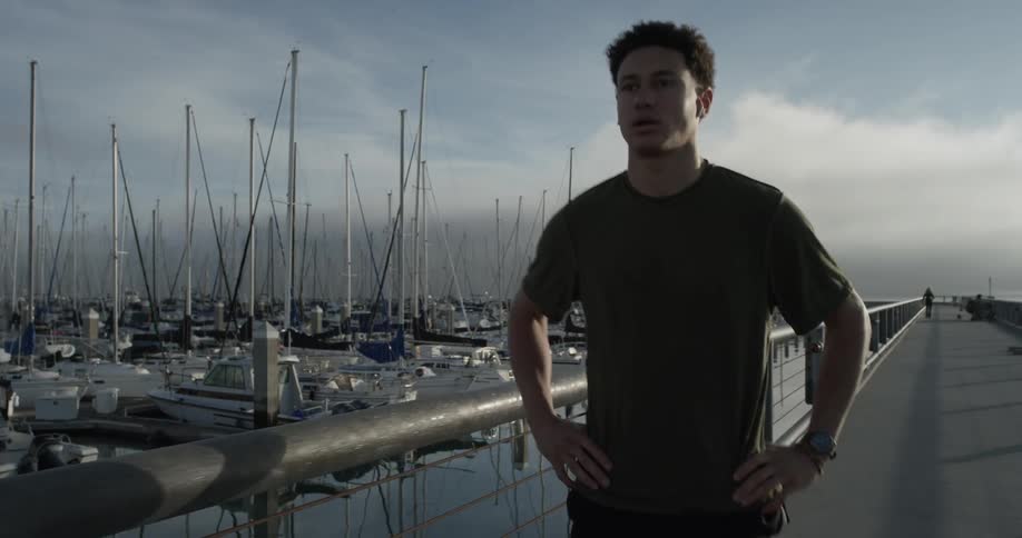 Man walking along a marina full of boats