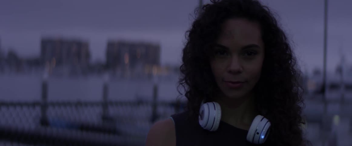 A woman with a pair of headphones around her neck