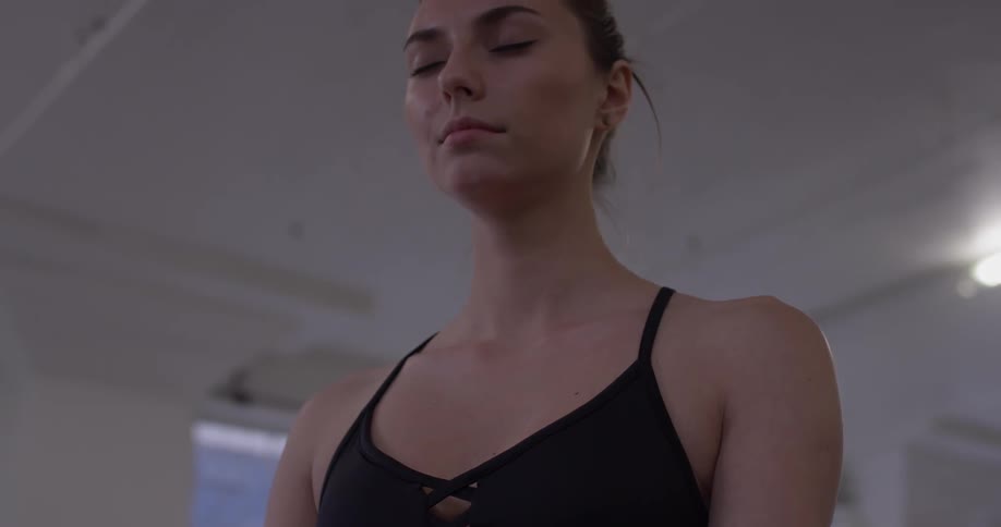 A woman stands and breathes deeply