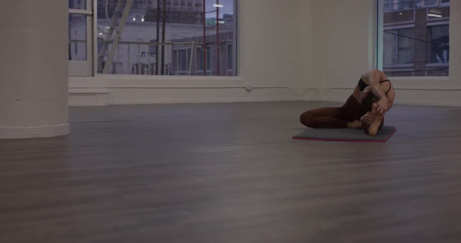 A woman does yoga on a yoga mat