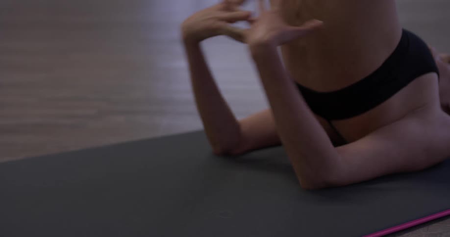 Woman does yoga poses on a mat