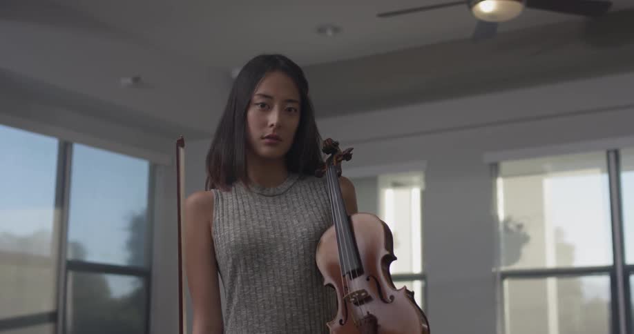 Woman standing in a room holding a violin
