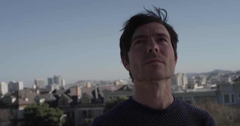 A man smiles after looking at the city around him