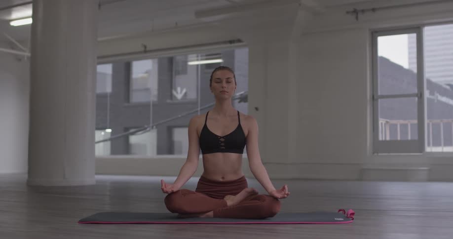 A woman sitting in a studio meditating