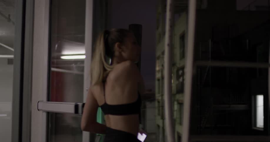 A woman walks through a door into a large dark room