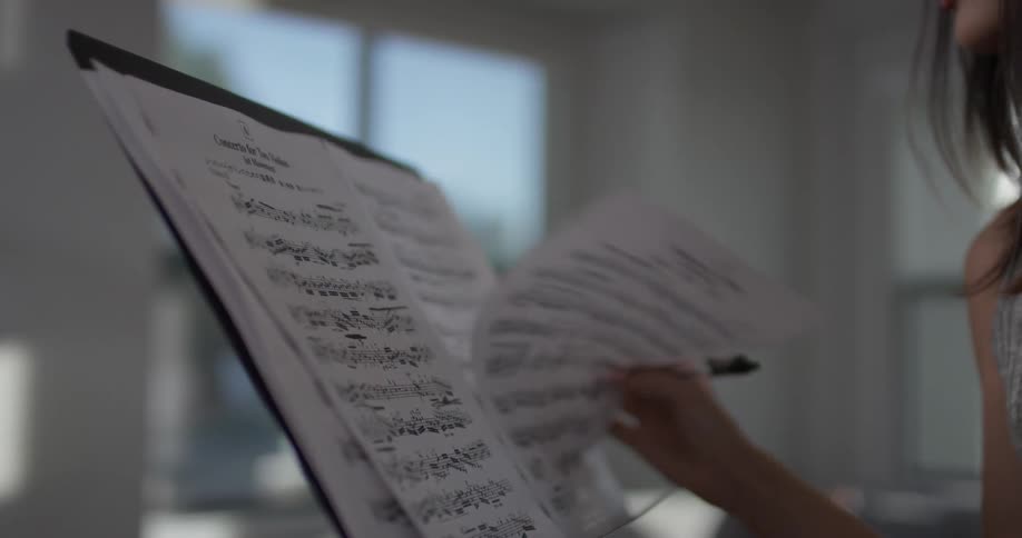 A woman turning pages on sheet music