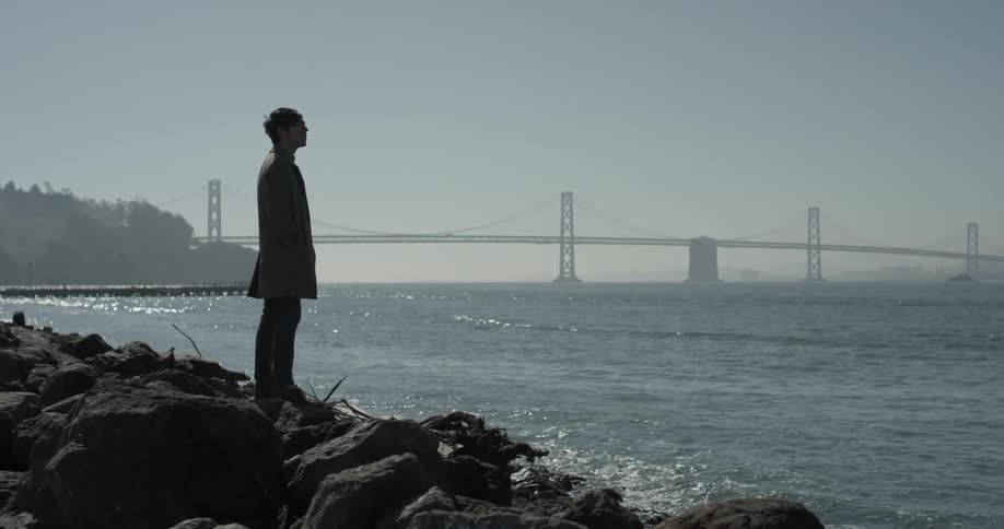 Man stands on rocks near water