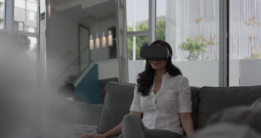 A woman is amazed by the virtual reality visor she is wearing