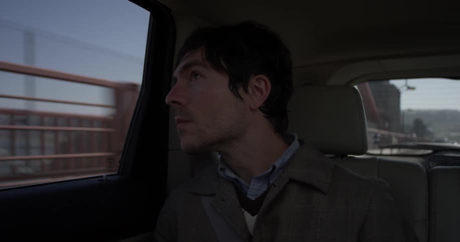 A male passenger looks out the moving vehicle