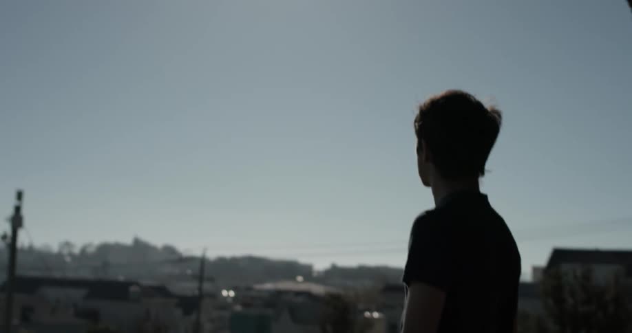 Man walks outside in a town on a sunny day