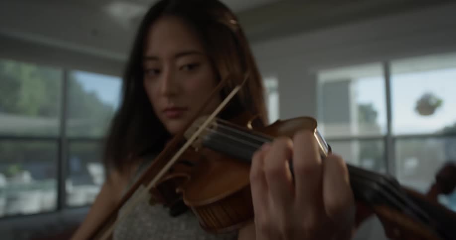 A woman energetically plays a violin