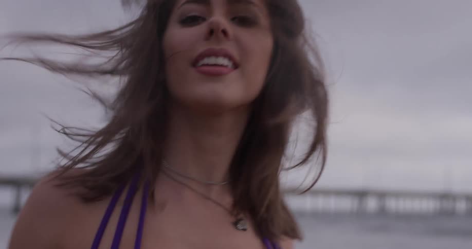 A woman models walking along the beach