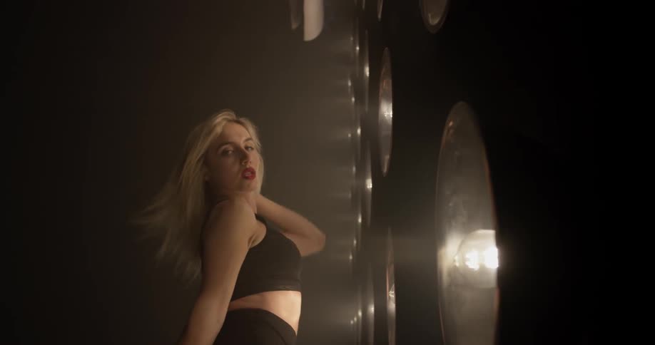 Woman dances in front of a large wall of lights