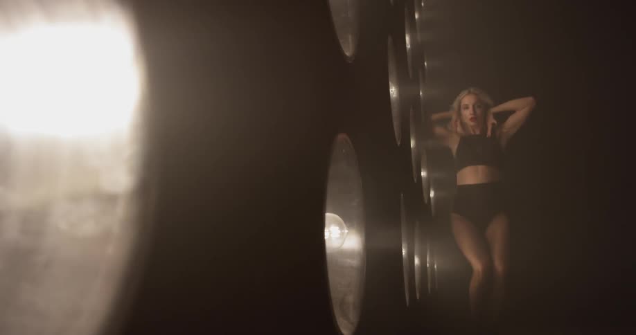 Woman dances in front of a large wall of lights