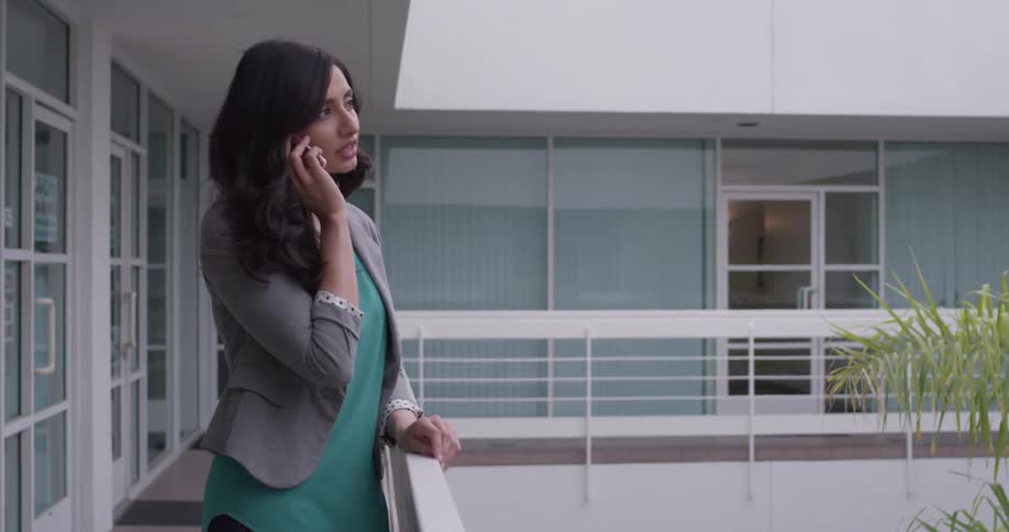 Woman on balcony talks on phone