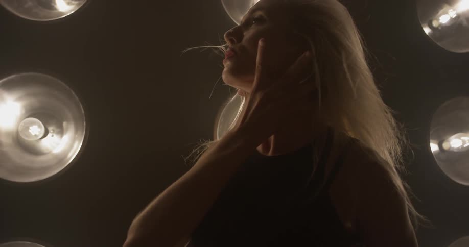 Woman dances in front of a large wall of lights