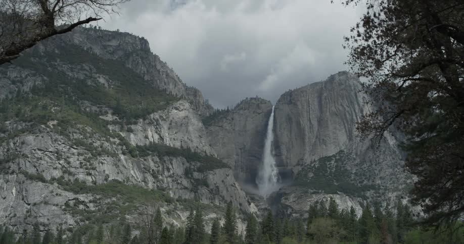 A slow moving view of a large mountain with clouds near the top of the mountain