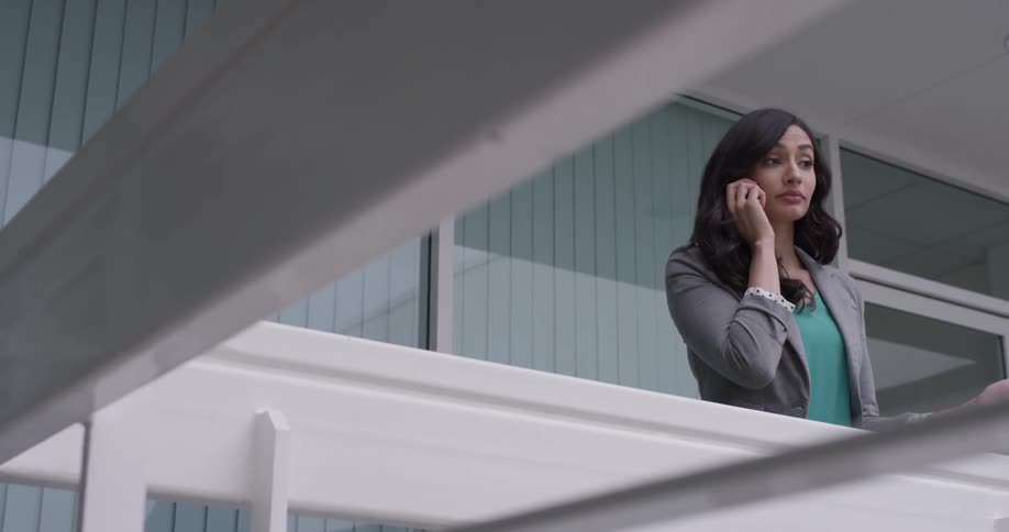 Woman talking on a phone on a balcony
