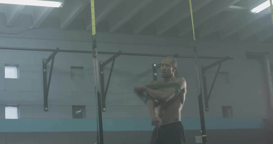 A man putting on his shirt at the gym
