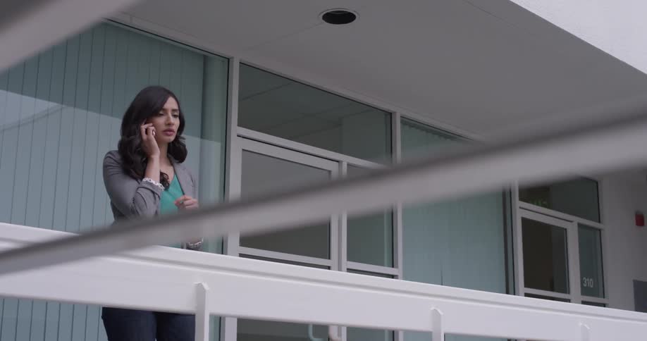 A woman on a deck is talking on the phone