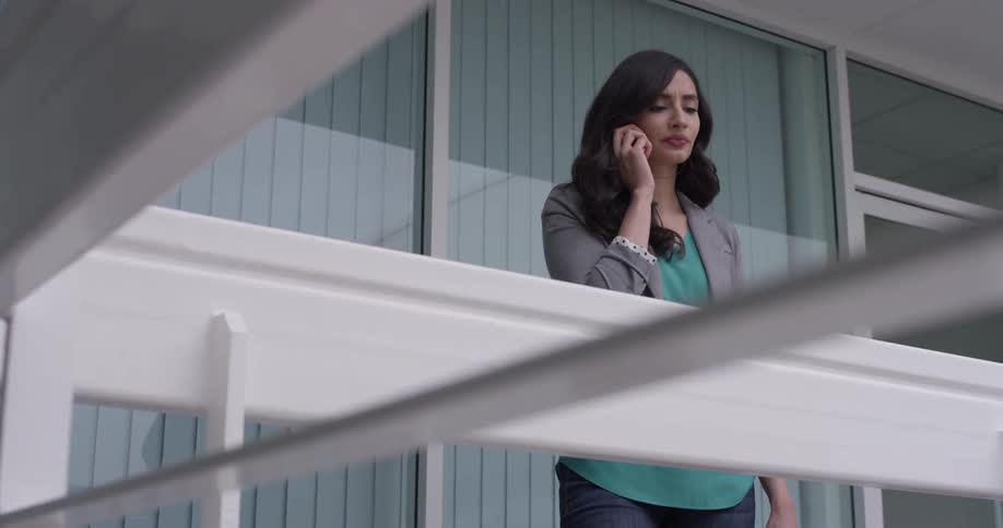 A woman is on the phone on a deck