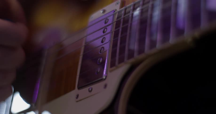 Someone plays a guitar at the sun shines on them