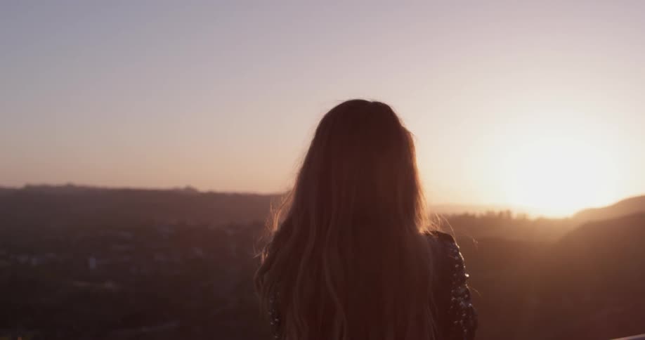 A woman is outside at sunset