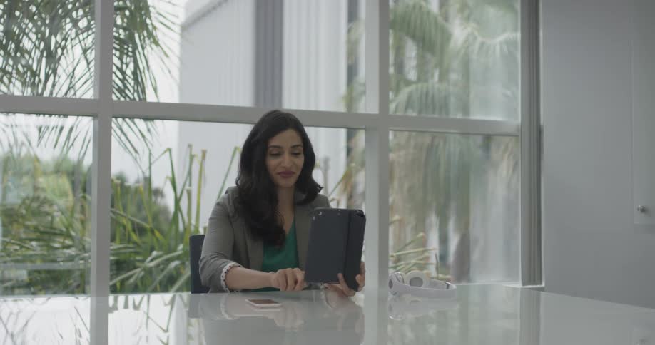 A woman looking at a tablet on a desk